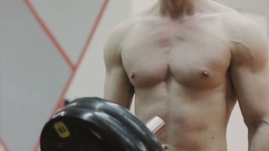 Atış kararlı kaslı adam ağır plakaları üzerinde halter koyarak ve jimnastik salonu kaldırma geçiş