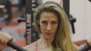 Çok güzel kadın eğitmen trenler bir fitness kulübünde fitness makinedeki