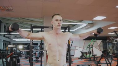 Eğitim salonunda dumbbells ile bir adamdır