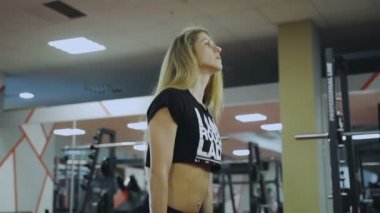 Kadın spor salonunda dumbbells ile eğitiyor