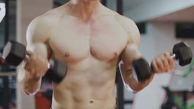 Eğitim salonunda dumbbells ile bir adamdır