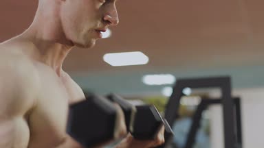 Eğitim salonunda dumbbells ile bir adamdır