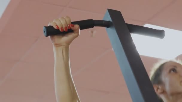 Fitnesstrainerin des Sportvereins macht Klimmzüge am Simulator zur Stärkung der Schultermuskulatur. eine Frau macht die Übungen richtig und zieht mit geradem Rücken nach oben — Stockvideo