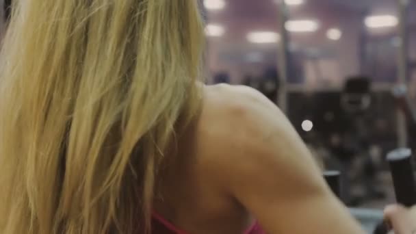 Очень красивая женщина-тренер тренируется на тренажере в фитнес-клубе — стоковое видео