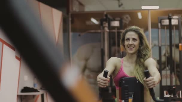 Très belle entraineuse sur un appareil de fitness dans un club de fitness — Video