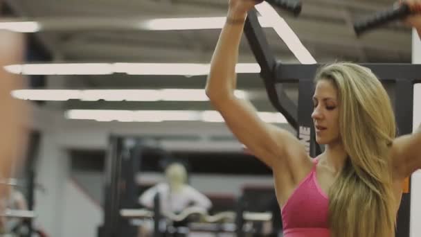 Zeer mooie vrouwelijke trainer treinen op een fitnesstoestel in een fitnessclub — Stockvideo
