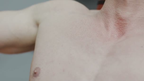 En muskulös man med en naken torso tåg på en fitness maskin i en fitness-klubben — Stockvideo