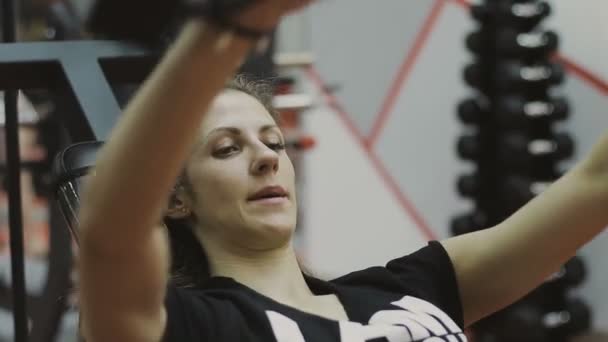 Very beautiful female trainer trains on a fitness machine in a fitness club — Stock Video