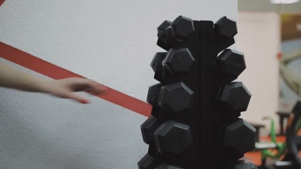 Hand of a young women taking a dumbbells at gym. — Stock Video