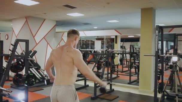 Een man is training met halters in de sportschool — Stockvideo