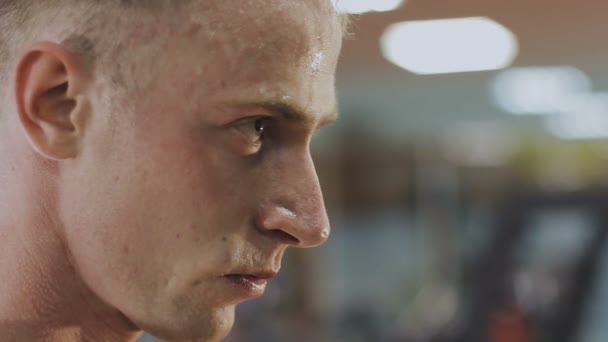 Un hombre está entrenando con pesas en el gimnasio. — Vídeos de Stock