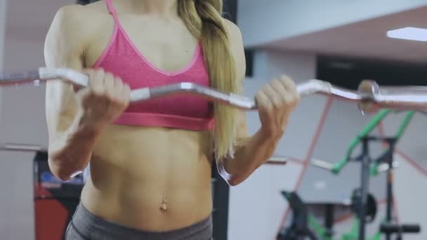 Kobieta jest szkolenie z barem na siłowni. Piękne ciało. — Wideo stockowe
