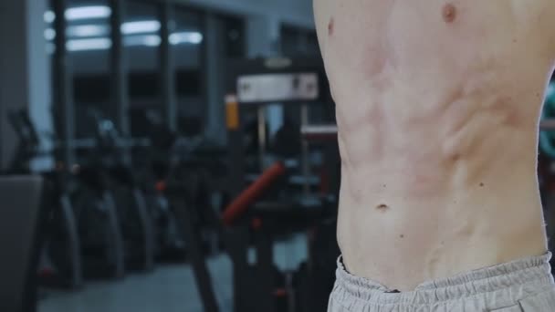O homem mostra os músculos abdominais após o treinamento no ginásio — Vídeo de Stock