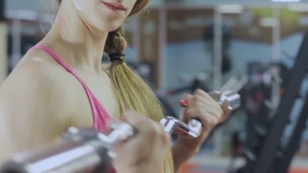 Kvinnan är utbildning med en bar i gymmet. Vacker kropp. — Stockvideo