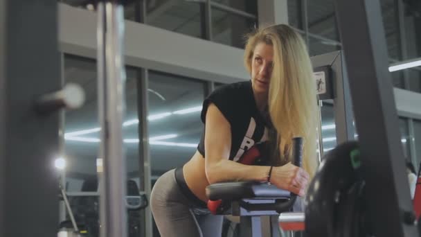 Sehr schöne Trainerin trainiert an einem Fitnessgerät in einem Fitnessclub — Stockvideo