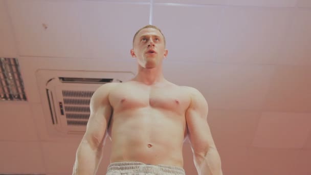 Un hombre está entrenando con pesas en el gimnasio. — Vídeo de stock