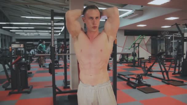 El hombre muestra los músculos abdominales después del entrenamiento en el gimnasio — Vídeo de stock