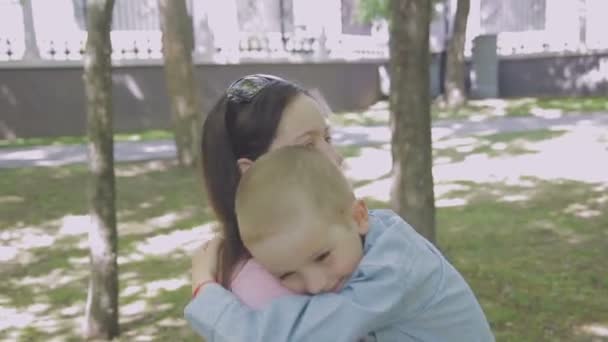 Familienspaziergänge im Park mit Kindern. sonniger Tag. grüne Bäume — Stockvideo