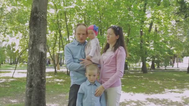 Aile ile çocuk parkta yürüyor. Güneşli bir gün. Yeşil ağaçlar — Stok video