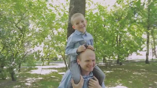 Familienspaziergänge im Park mit Kindern. sonniger Tag. grüne Bäume — Stockvideo