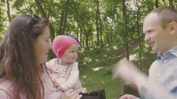 Familienspaziergänge im Park mit Kindern. sonniger Tag. grüne Bäume — Stockvideo