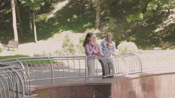 Paseos familiares en el parque con niños. Día soleado. Árboles verdes — Vídeo de stock