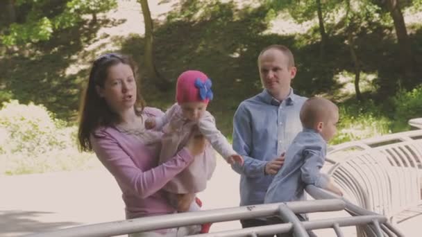 Familie wandelingen in het park met kinderen. Zonnige dag. Groene bomen — Stockvideo