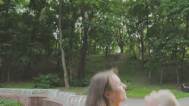 Aile ile çocuk parkta yürüyor. Güneşli bir gün. Yeşil ağaçlar — Stok video