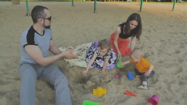 Família caminha no parque com crianças. Dia ensolarado. Árvores verdes — Vídeo de Stock