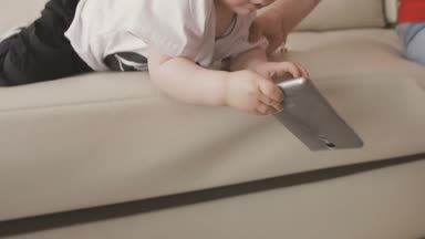 Küçük bir çocuk bir smartphone ile oynuyor. Aile evde