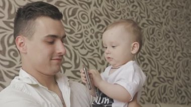 Küçük bir çocuk bir smartphone ile oynuyor. Aile evde