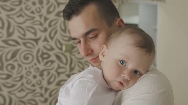 Father holds a small child in his arms. Family at home — Stock Video