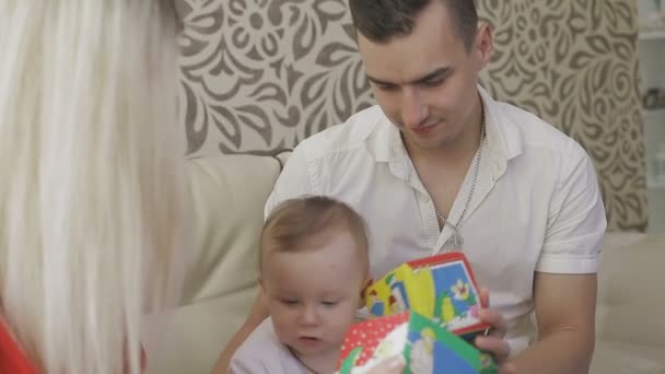 Pai e mãe estão brincando com seu filhinho. Família em casa — Vídeo de Stock