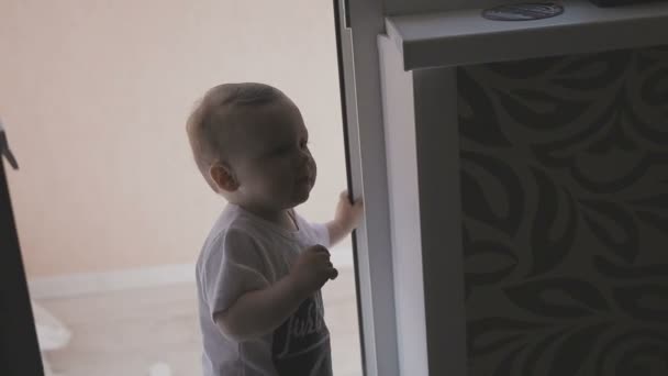 Un niño pequeño camina por el apartamento mientras los padres no ven. Familia en casa — Vídeo de stock