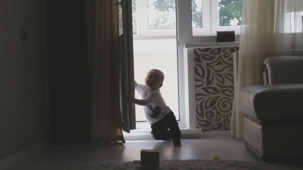 Ett litet barn går runt i lägenheten medan föräldrar inte ser. Familjen hemma — Stockvideo