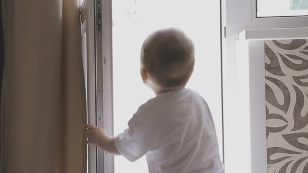 Un niño pequeño camina por el apartamento mientras los padres no ven. Familia en casa — Vídeos de Stock