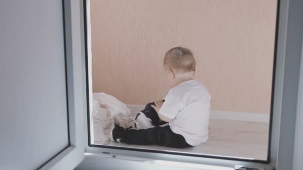 A small child walks around the apartment while parents do not see. Family at home — Stock Video