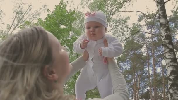 Schöne Frau läuft mit ihrer kleinen Tochter und schiebt Kinderwagen in Park — Stockvideo