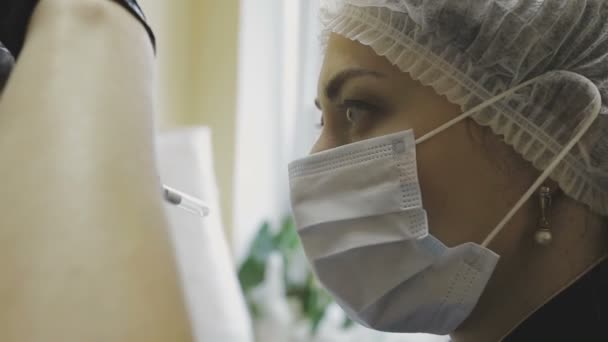 De werknemer van de kliniek cosmetologie maakt manipulaties op de kleur van de wenkbrauwen — Stockvideo