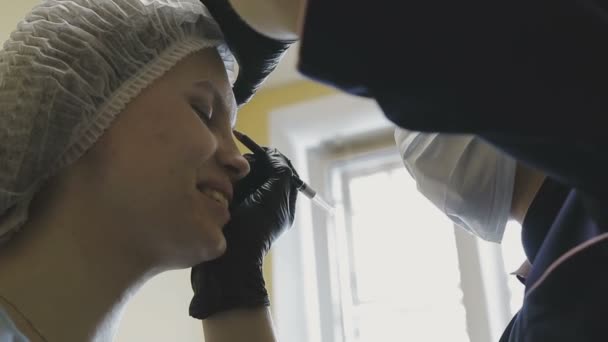 Zaměstnanci kliniky kosmetika dělá manipulace na barvení obočí — Stock video