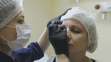 Bir kozmetik klinik bir kadın işçiye biçimlendirme önce microblasting yordam yapar