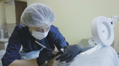 Bir kozmetik klinik bir kadın işçilerin microblasting rutin bir bayan hasta yapar.
