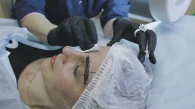 Bir kozmetik klinik bir kadın işçilerin microblasting rutin bir bayan hasta yapar.