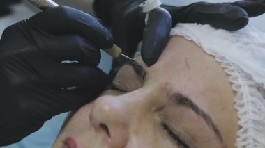 Bir kozmetik klinik bir kadın işçilerin microblasting rutin bir bayan hasta yapar.