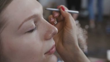 Çok güzel bir kız bir fotoğraf Studio için profesyonel makyaj makyaj sanatçısı yapar