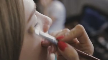 Çok güzel bir kız bir fotoğraf Studio için profesyonel makyaj makyaj sanatçısı yapar