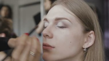 Çok güzel bir kız bir fotoğraf Studio için profesyonel makyaj makyaj sanatçısı yapar