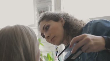 Çok güzel bir kız bir fotoğraf Studio için profesyonel makyaj makyaj sanatçısı yapar