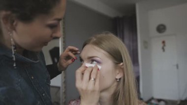 Çok güzel bir kız bir fotoğraf Studio için profesyonel makyaj makyaj sanatçısı yapar