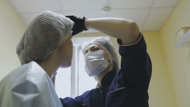 Zaměstnanci kliniky kosmetika dělá manipulace na barvení obočí — Stock video